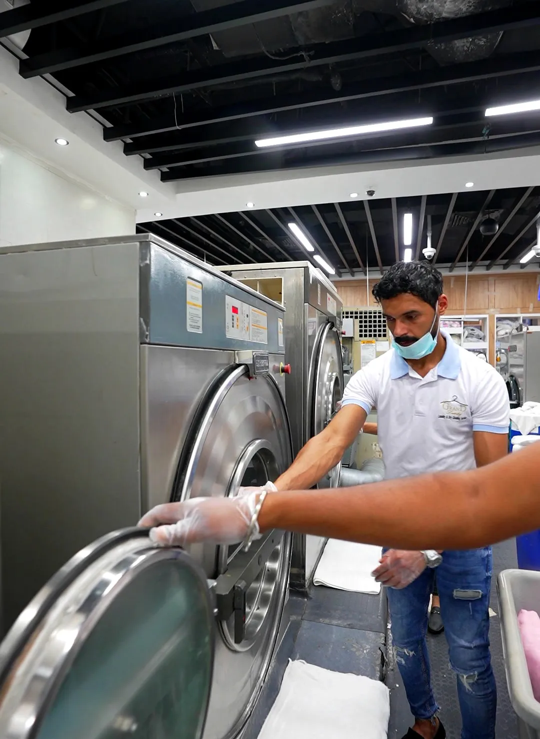 Grand Laundry team working at the industrial washing machines in Abu Dhabi