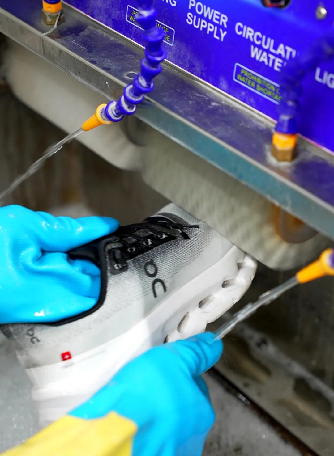 Sneaker being washed by hand in the shoe cleaning machine at Grand Laundry
