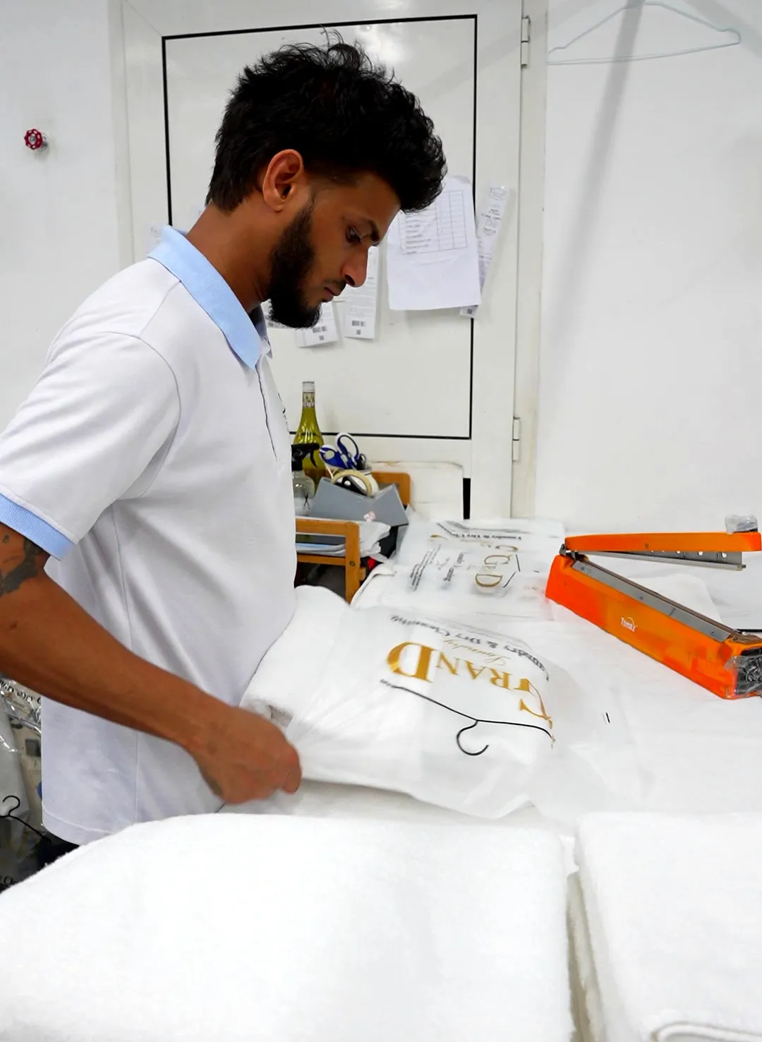 Clean towels being folded and packed at Grand Laundry, Abu Dhabi